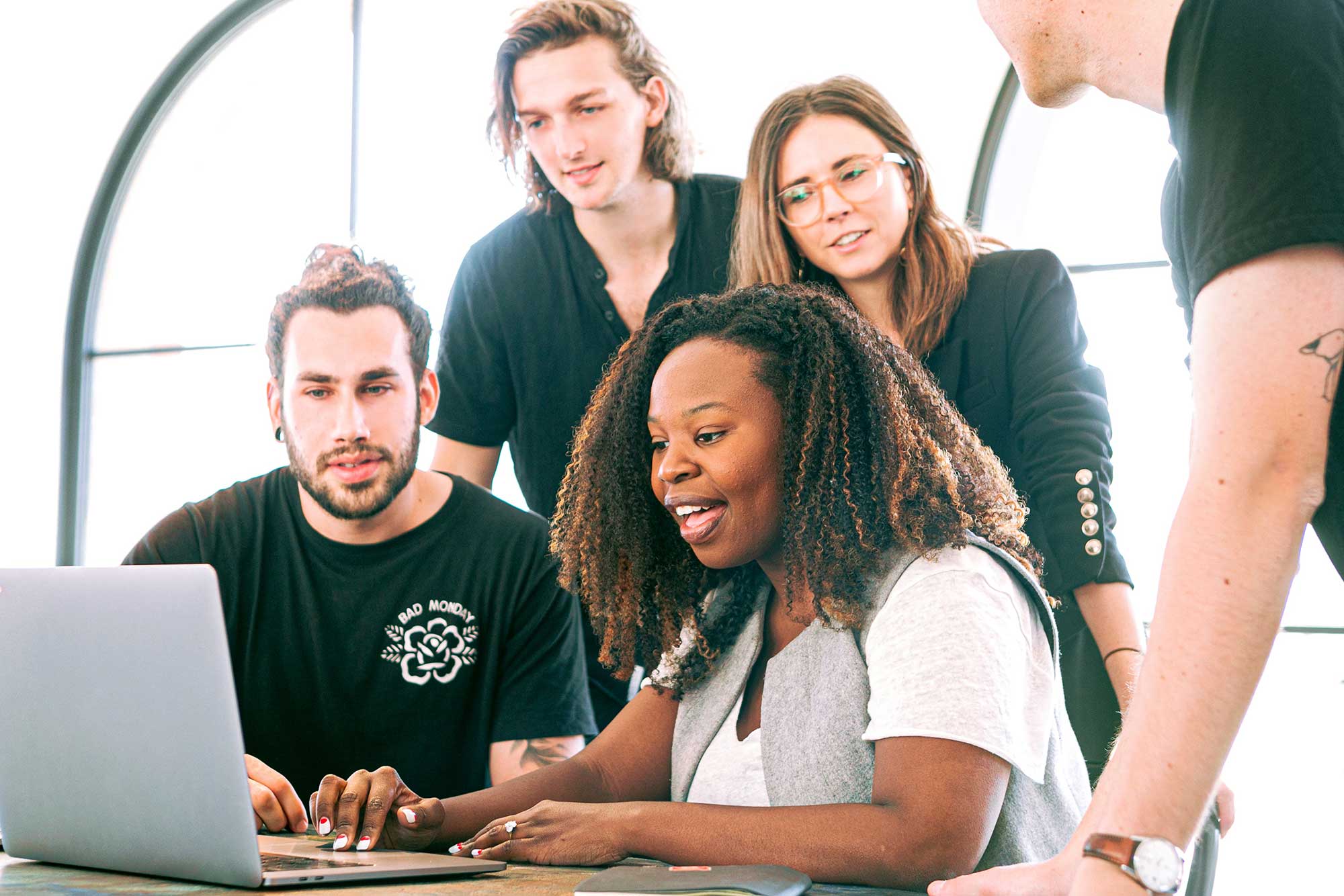 Marketing automation playbook cover image - Team members collaborating around laptop representing email marketing automation strategies