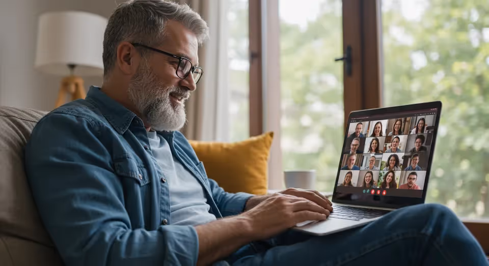 Homem em videoconferência, sorrindo durante reunião.