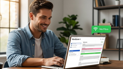 Homem sorridente utiliza o Wordtune AI no laptop, com indicação de conexão estável.