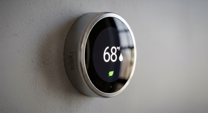 Termostato Nest digital marcando 68 graus e folha verde.