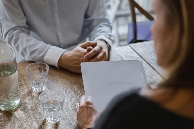 A family law attorney meeting with a client across a desk to review paperwork