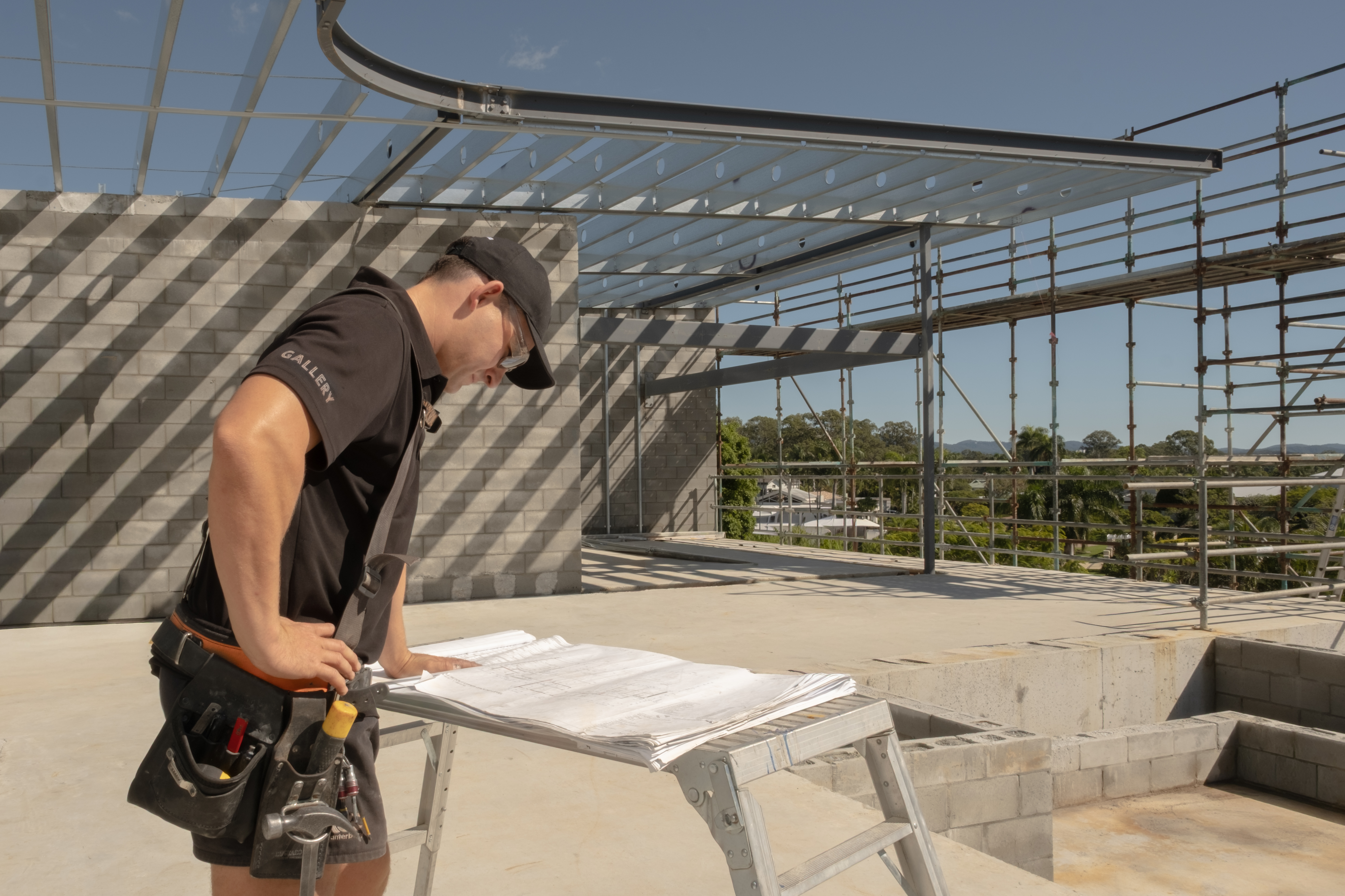 Gallery team member reviewing building plans on a construction site