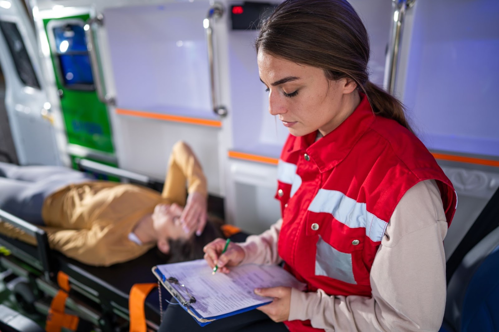 EMT charts vitals while bedside with a patient