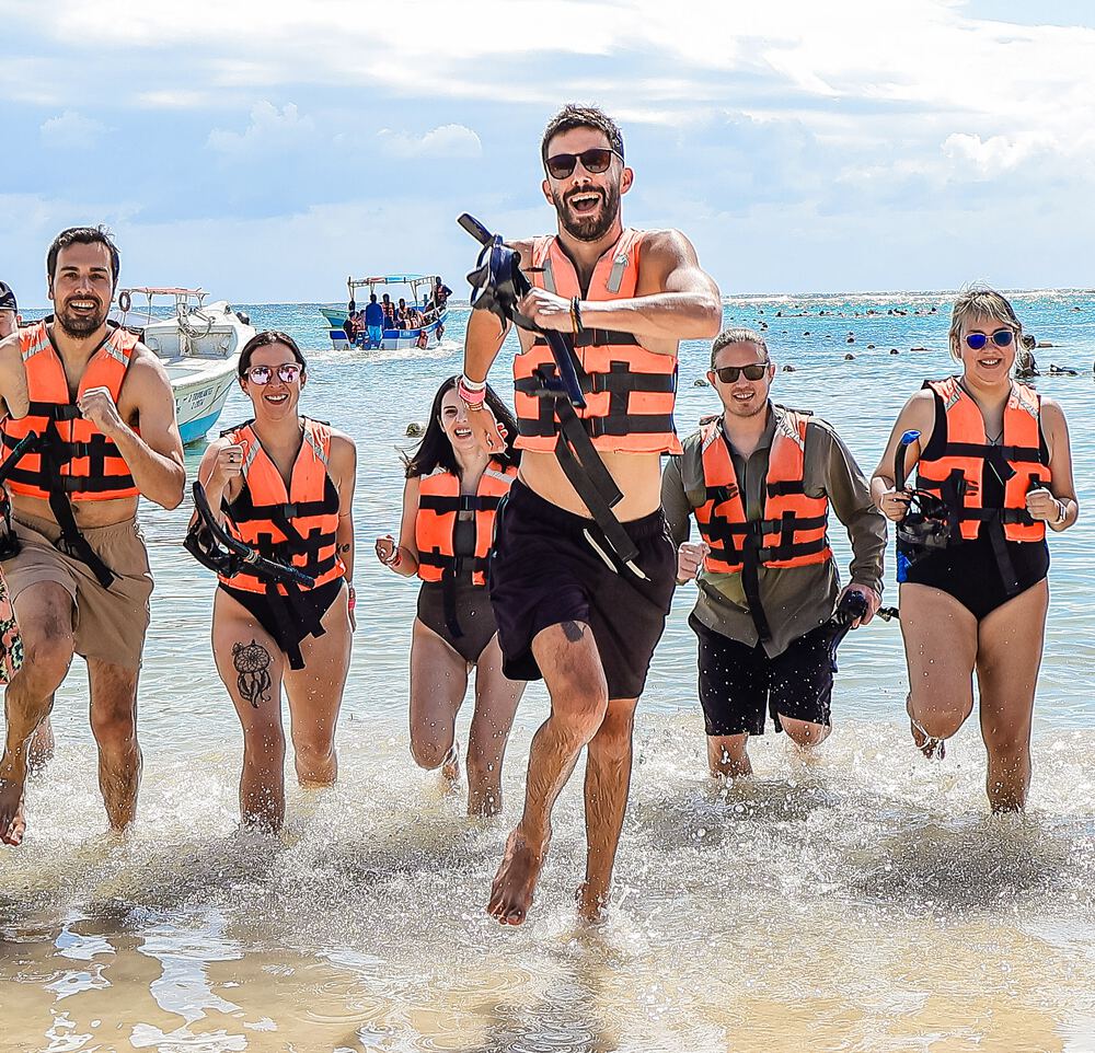 Distru teammates in life jackets running out of the sea at the Tulum offsite