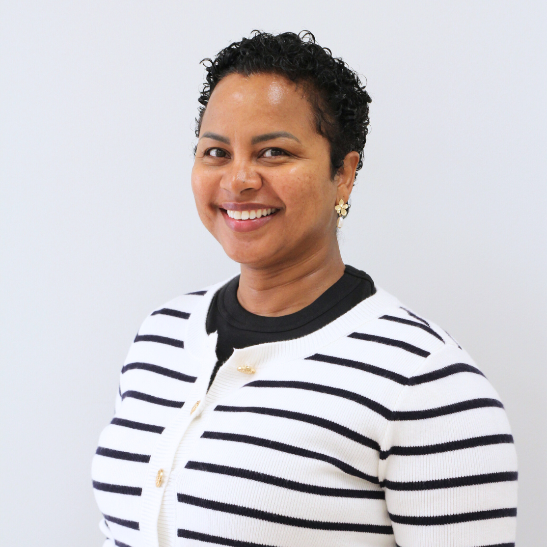 Ruta's headshot in stripped black and white sweater.