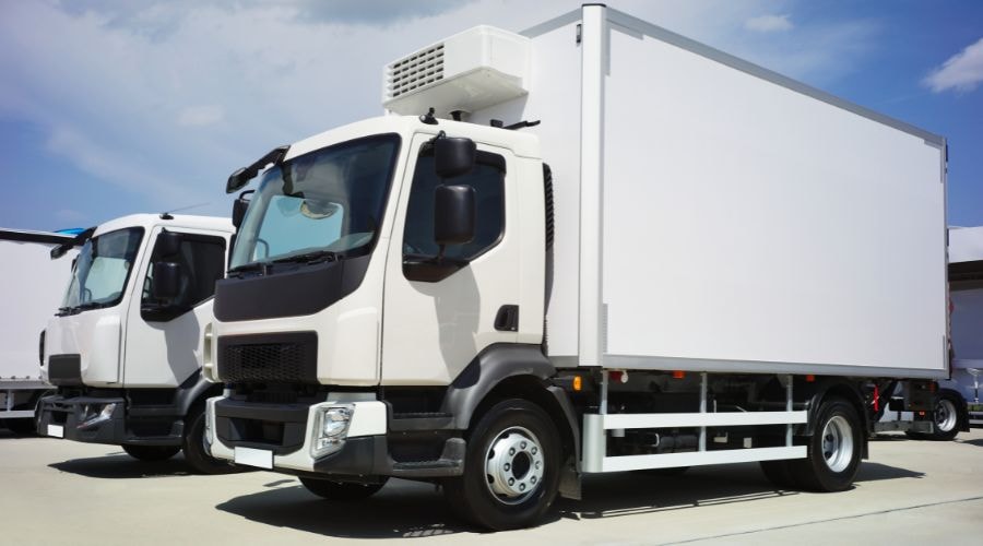 White refrigerated trucks parked in a lot
