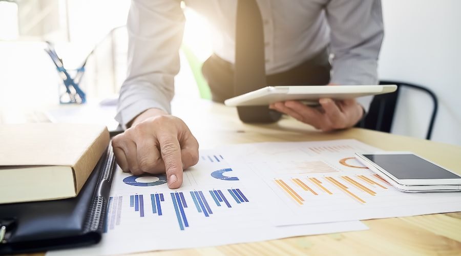 Businessman analyzing financial charts with a tablet and smartphone on desk