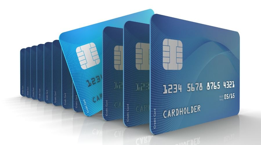 Row of blue credit cards with chip and cardholder details.