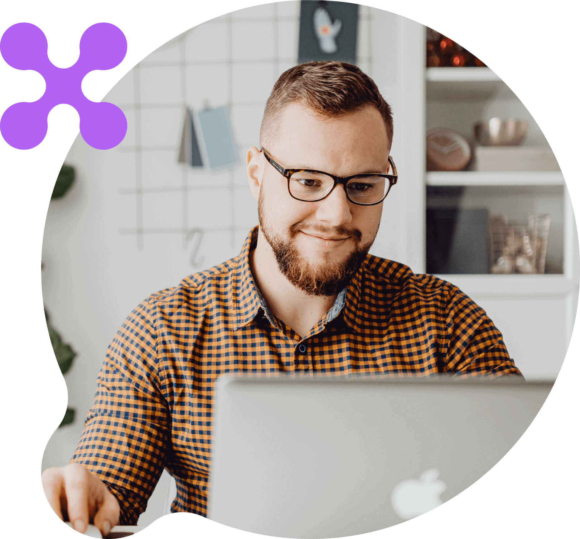 An image of a smiling man working in front a computer 