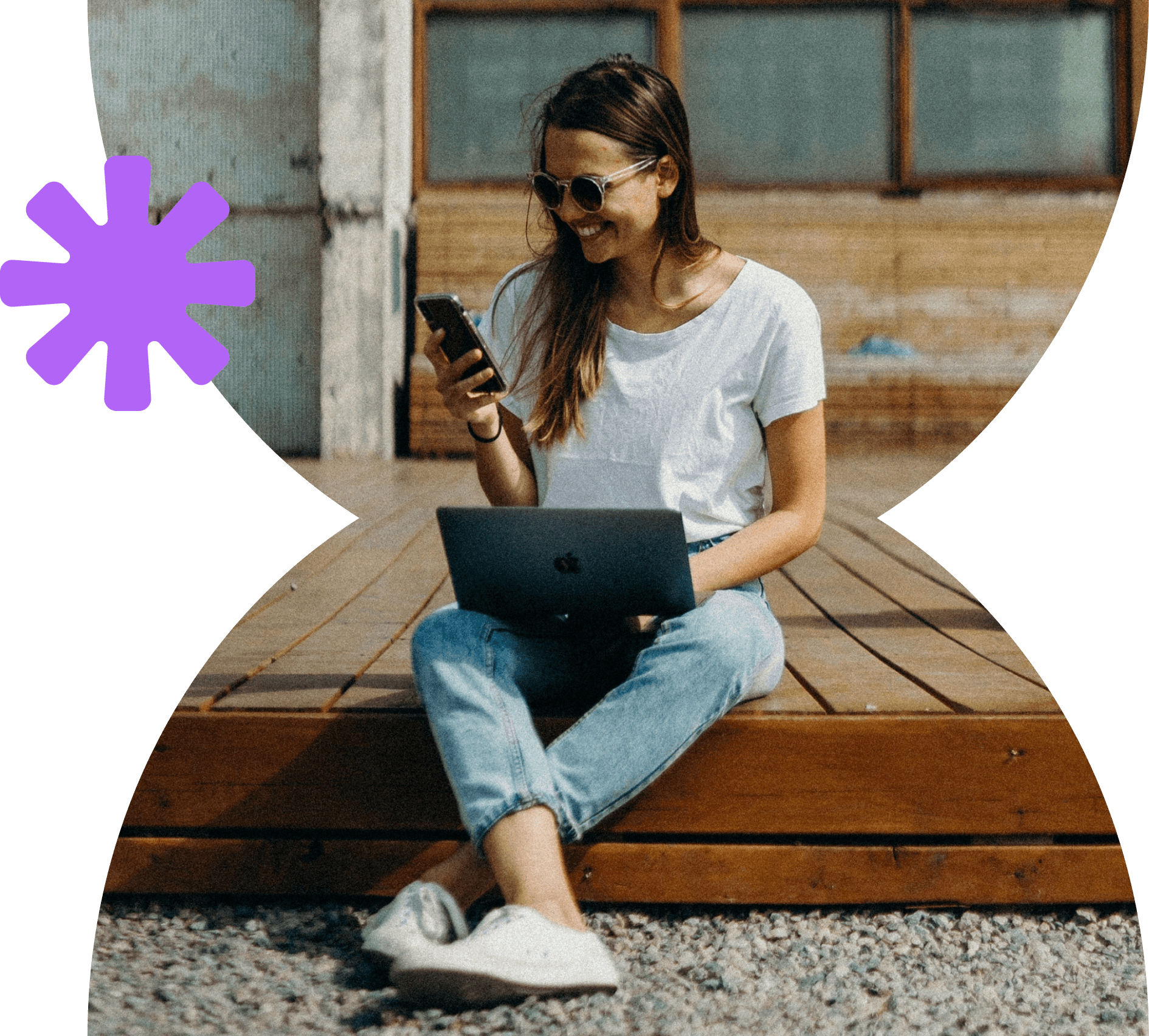 An image of a smiling woman sitting on the floor with a computer and phone