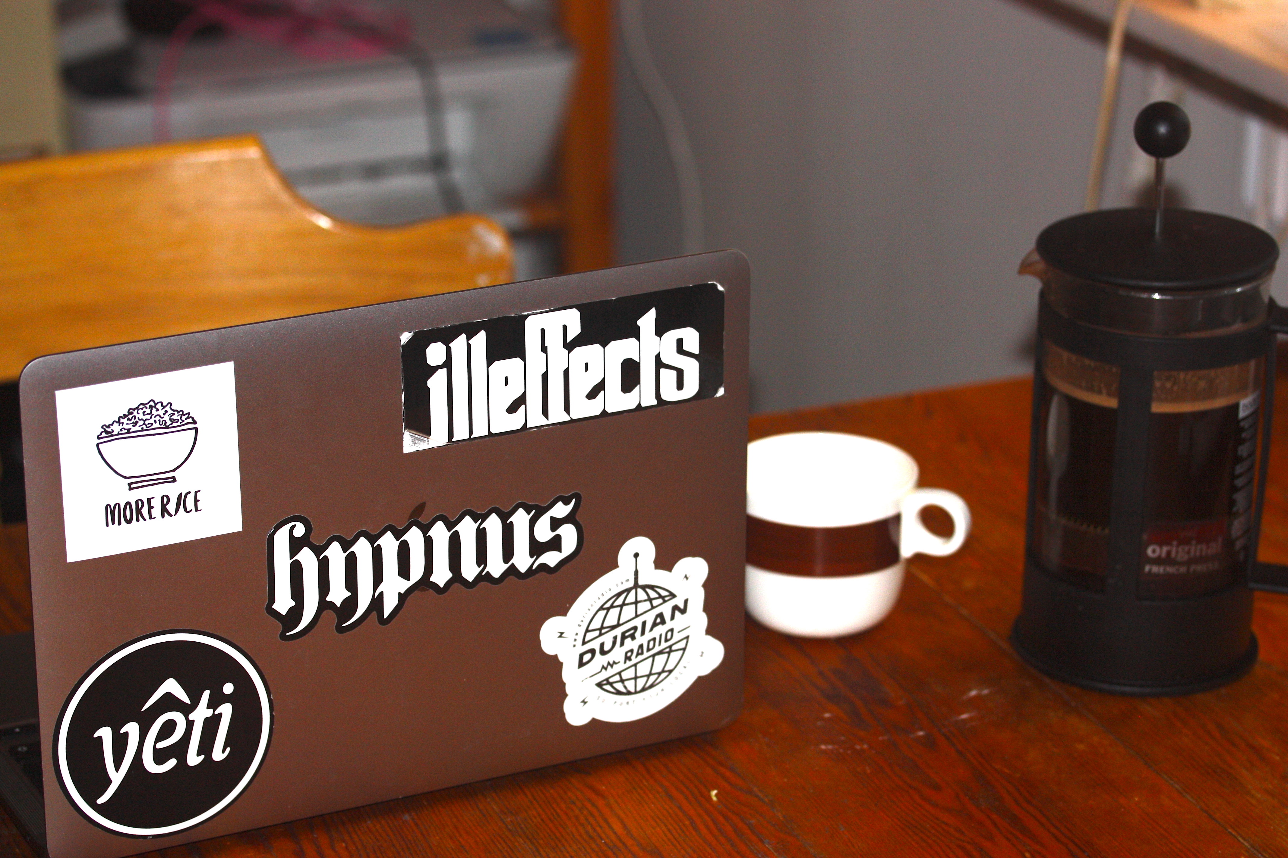 A laptop and a french coffee press.
