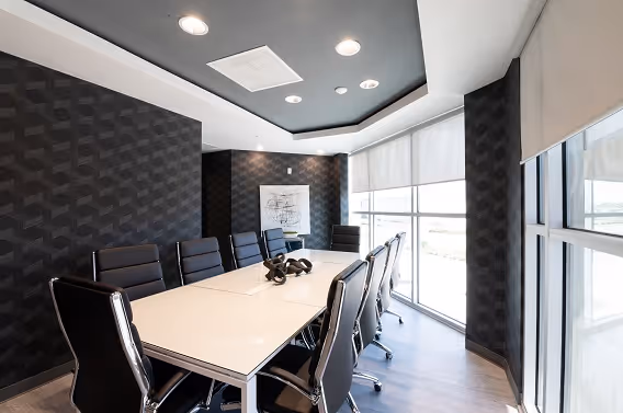 High-tech conference room at The Worx Orlando, equipped with a large conference table, comfortable seating for 10, and state-of-the-art audio-visual technology