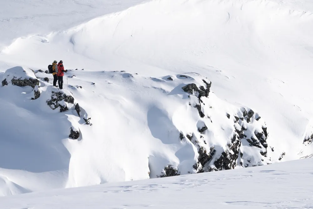 Two mountains guides looking down a ravine