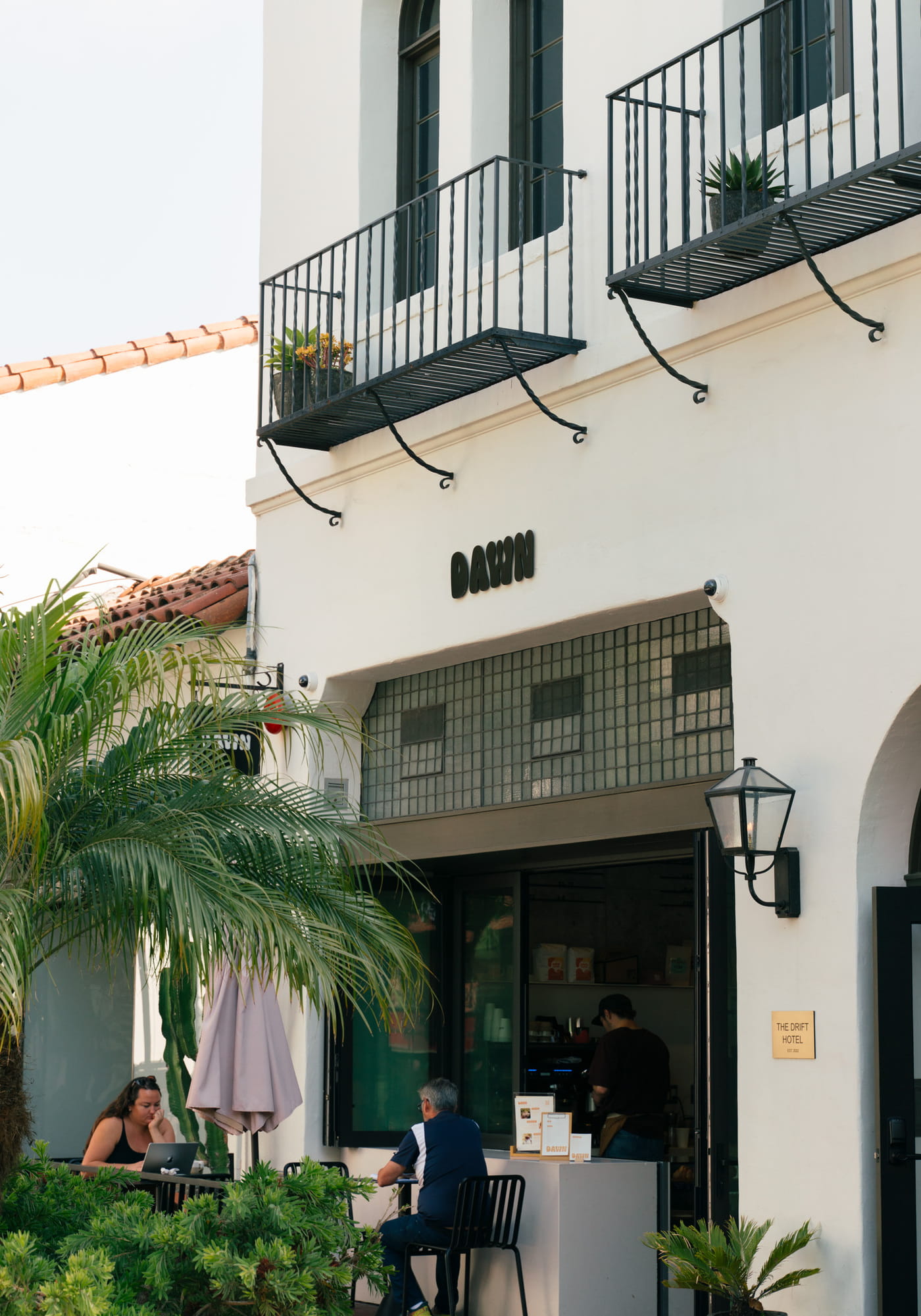 Dawn cafe exterior at The Drift Hotel with Spanish colonial architecture and outdoor seating
