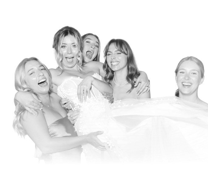 Man in a shiny silver tuxedo kissing a smiling woman on the cheek in a black and white glam photo booth
