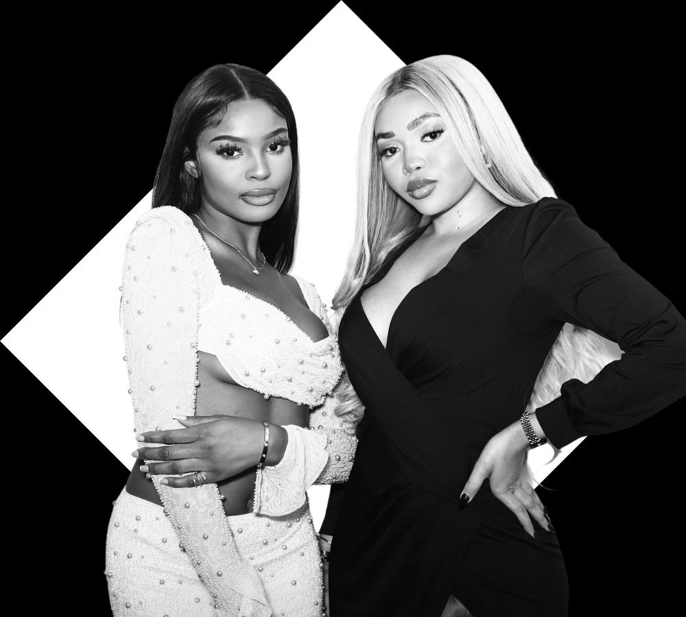 Four women dressed in glam outfits posing in black and white with oversized sunglasses and fun photo booth accessories