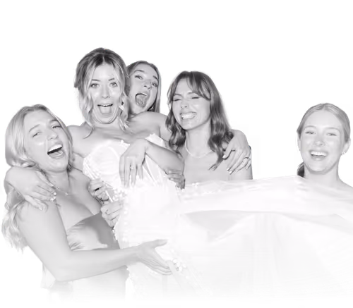 Group of five joyful young women posing closely together with big smiles and laughter.