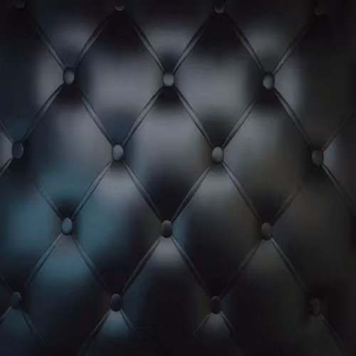Close-up of black tufted leather upholstery with diamond pattern and buttons.