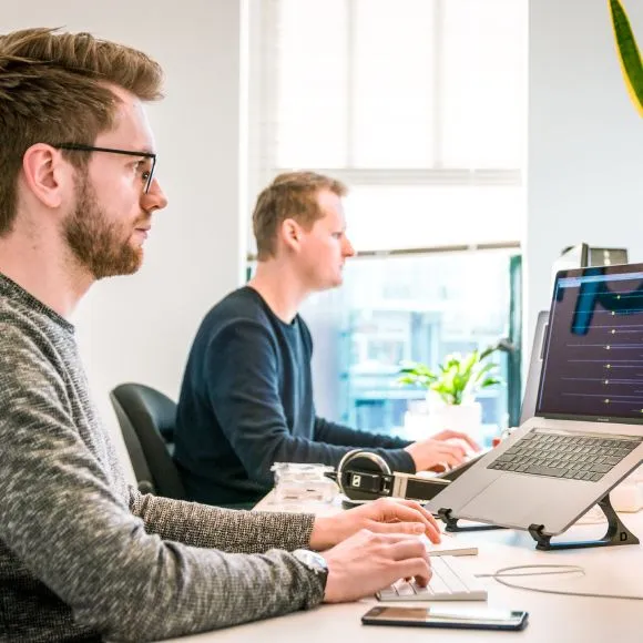 équipe de deux hommes qui travaillent sur des ordinateurs