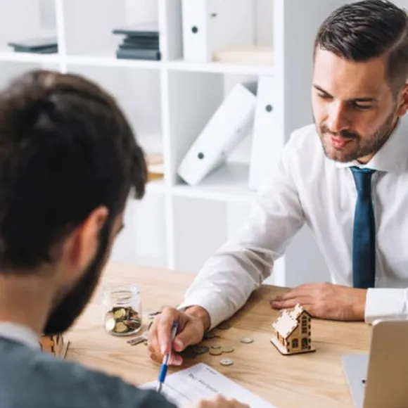 un commercial parle avec un client et lui montre un document avec des chiffres