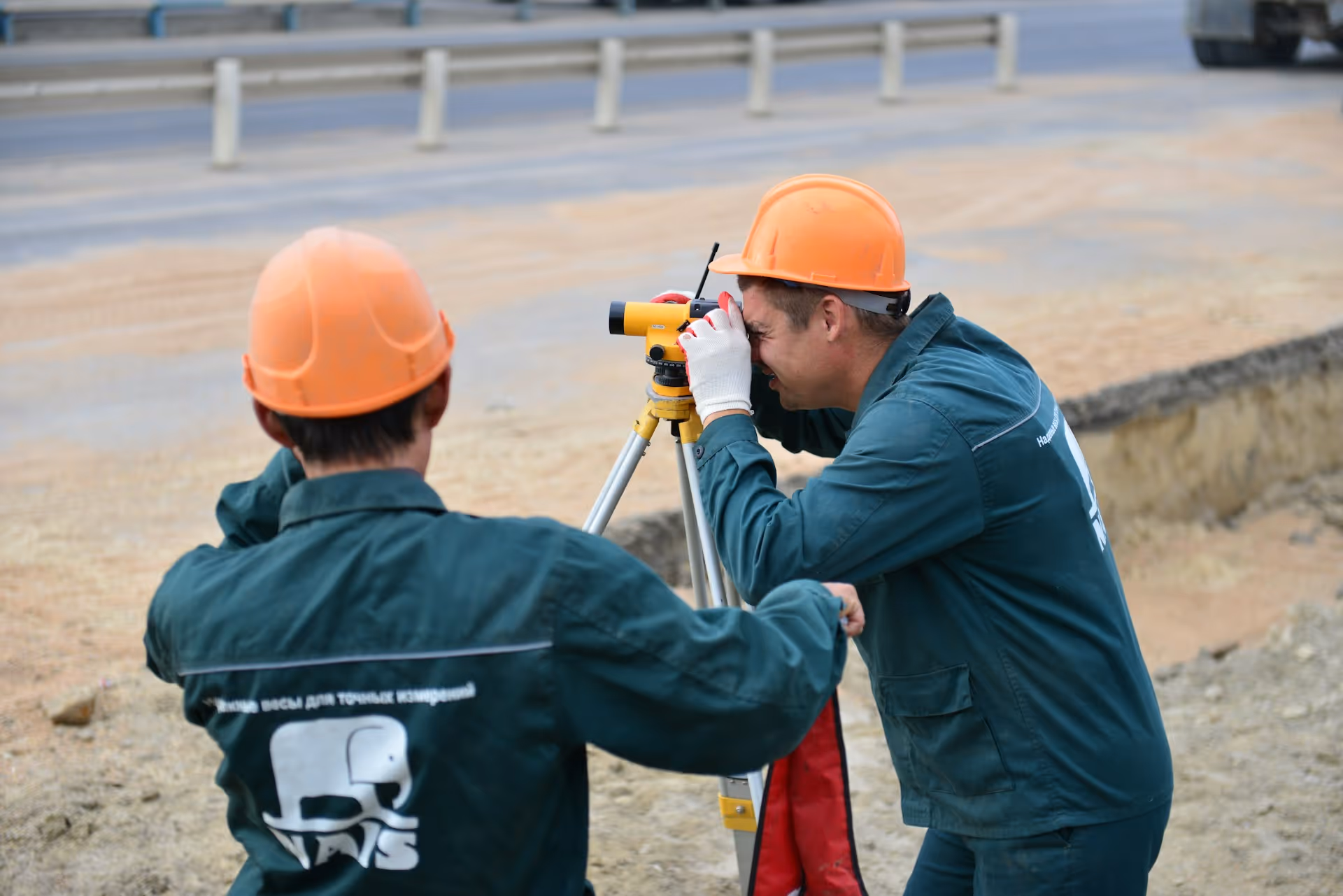 Zwei Männer stehen neben einem Vermessungsgerät
