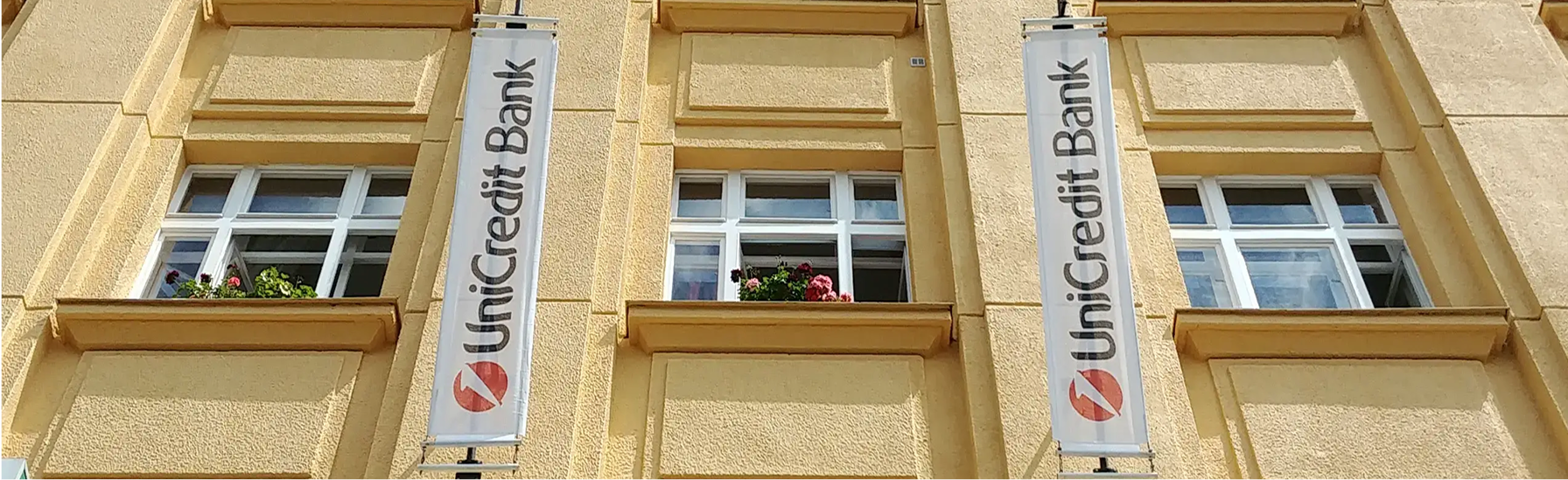 Reklamní vlajky UniCredit Bank na fasádě domu