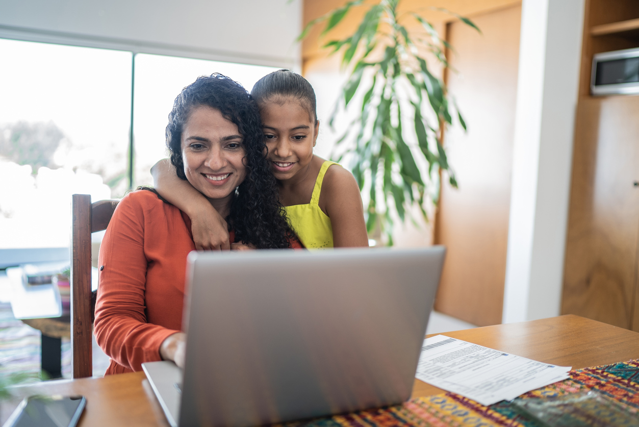 Mother and daughter using laptop at home