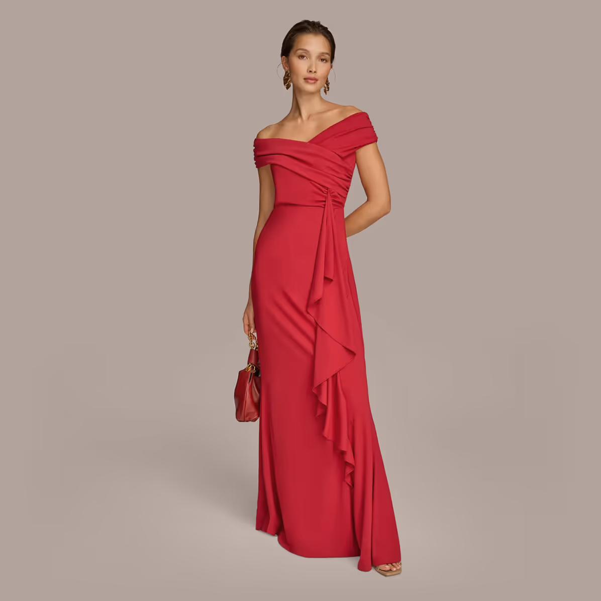 Woman wearing an elegant off-shoulder red evening gown with ruffle detail, holding a matching red handbag.