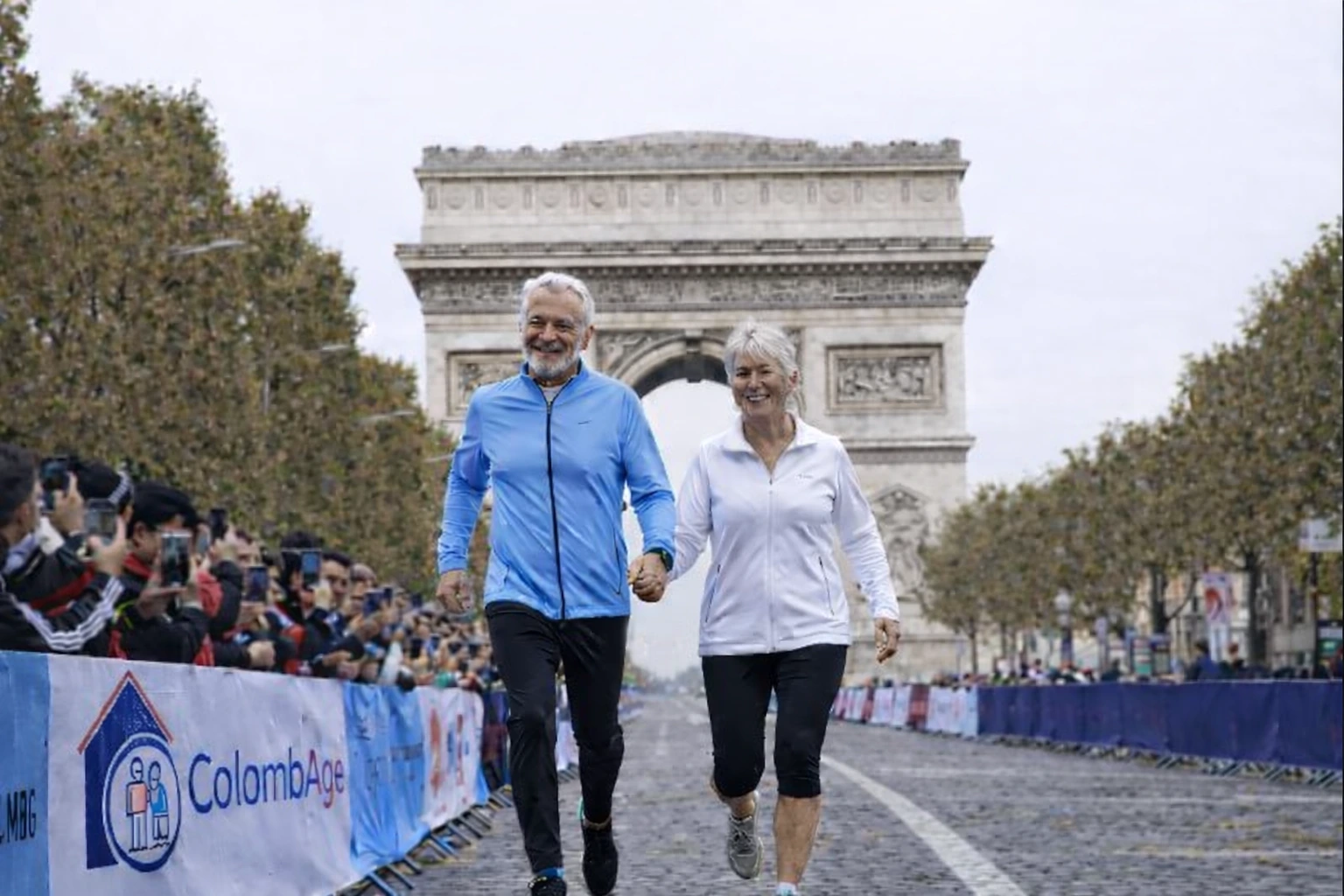 Couple de seniors qui courent en face de l' Arc de Triomphe