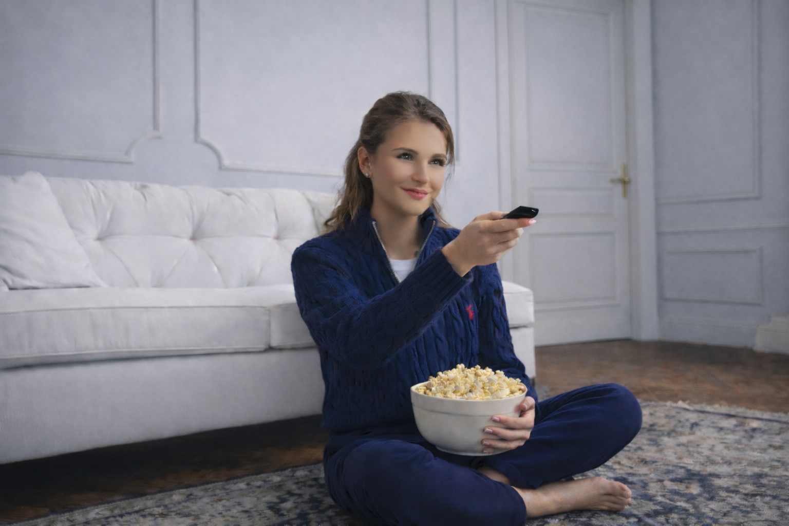Une jeune femme regarde la télévision de façon chill