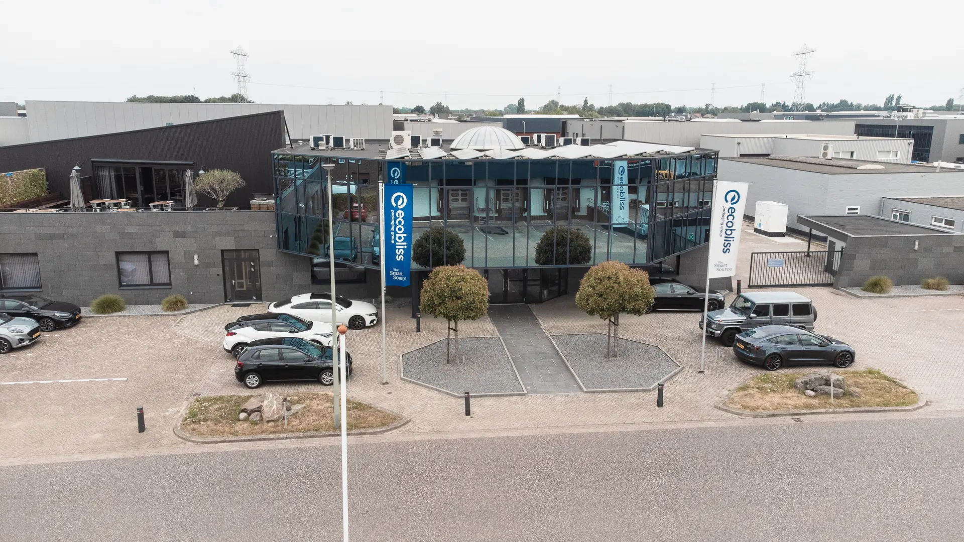 Aerial view of the Ecobliss headquarters in Echt, the Netherlands, with flags at the entrance