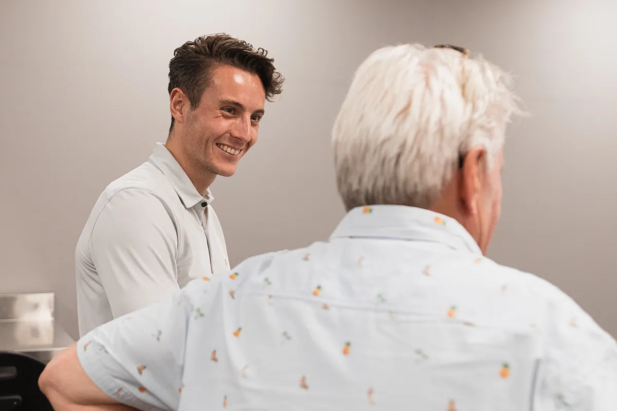 Smiling young employee talking with a senior colleague in a workshop room