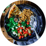 Colourful bowl of fresh food, including chickpeas, yoghurt and fresh vegetables
