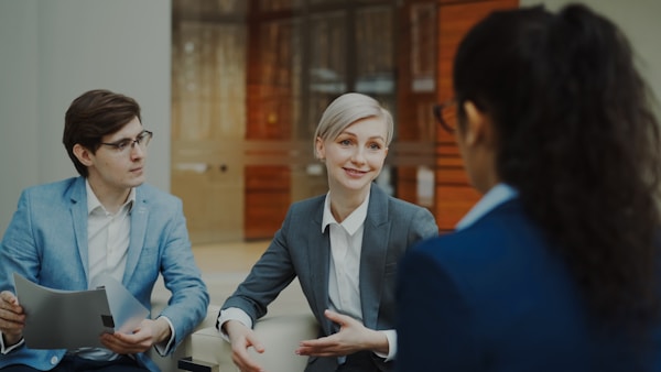 Three professionals in suits having a business meeting