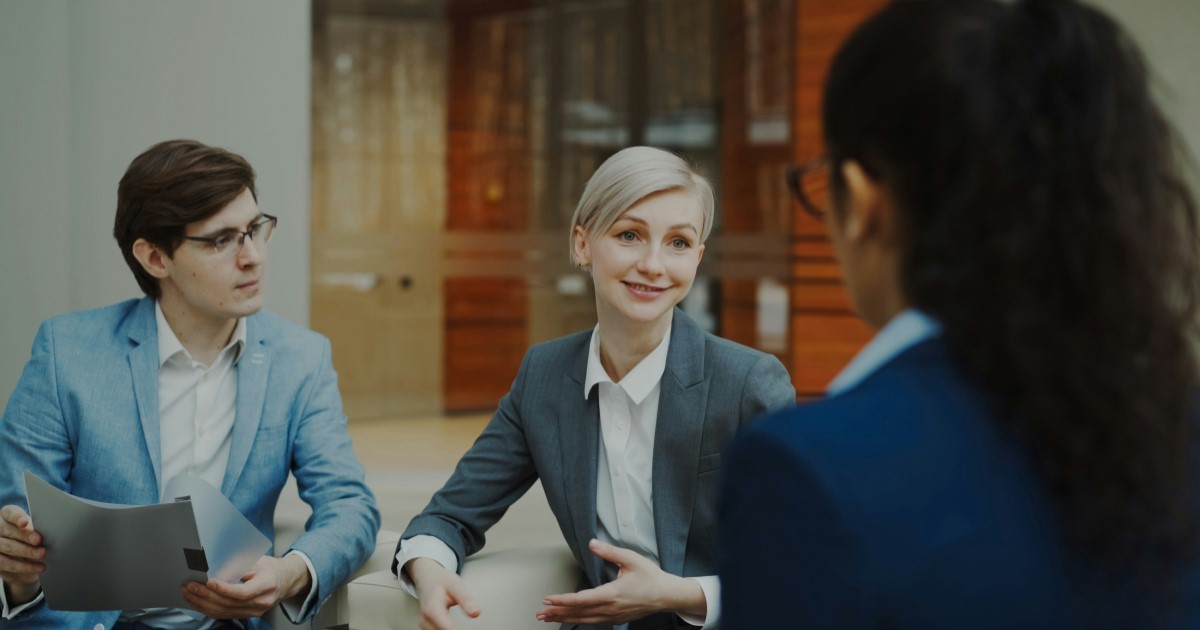 Three professionals discussing sustainability evidence in a business meeting