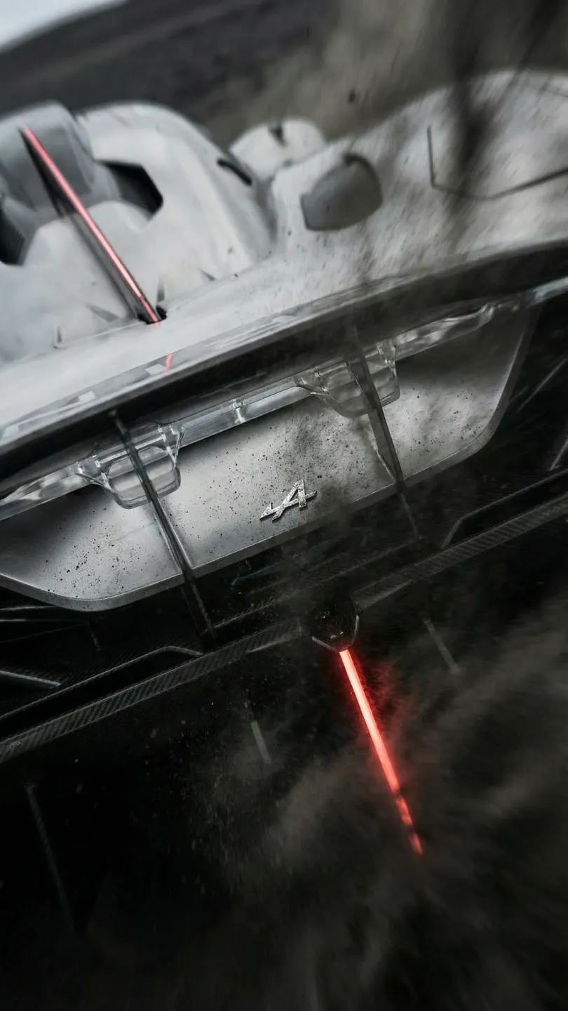 Nahaufnahme des Heckflügels eines Rennwagens mit rotem Bremslicht und Alpine-Logo.