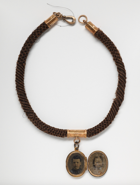 A necklace with two pendantsAI-generated content may be incorrect.