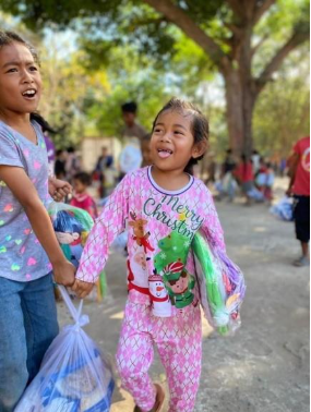 A child in pajamas holding a bag with her tongue outAI-generated content may be incorrect.