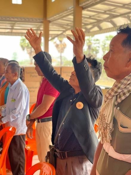 A group of people raising their handsAI-generated content may be incorrect.