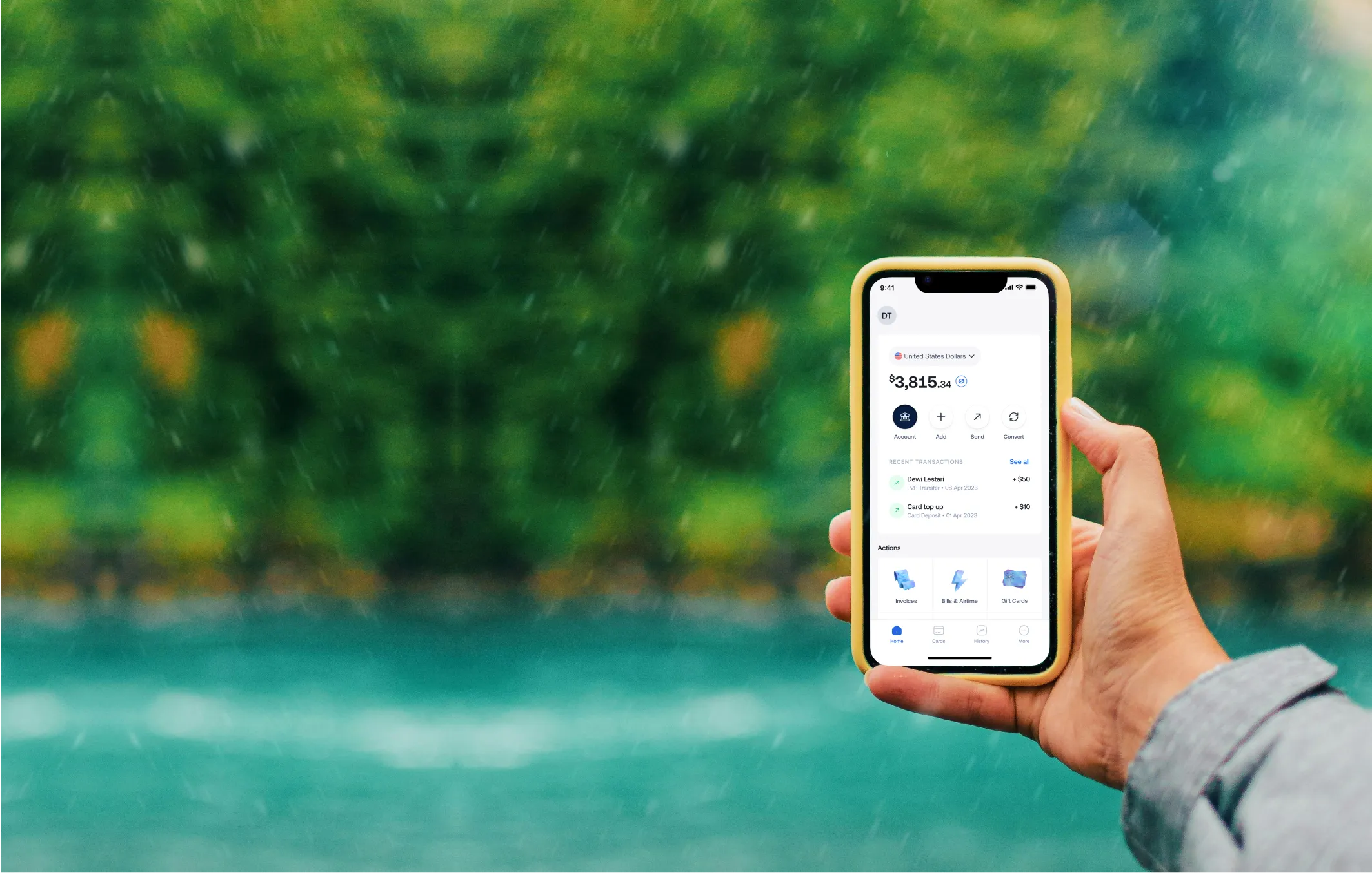 Hand holding smartphone displaying digital wallet app with account balance and recent transactions.