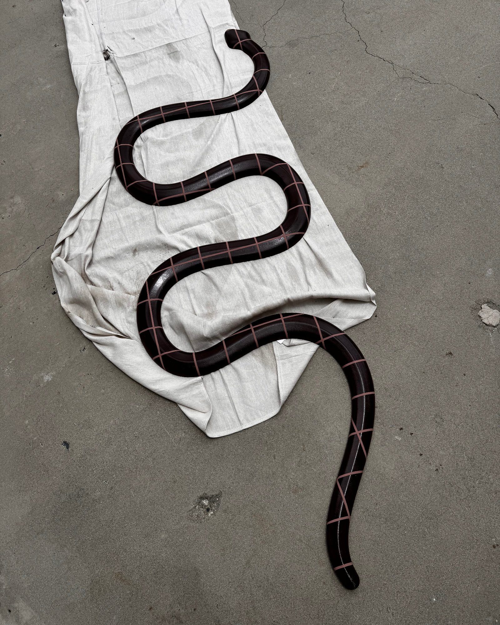 Sculpted serpent element with painted grid lines