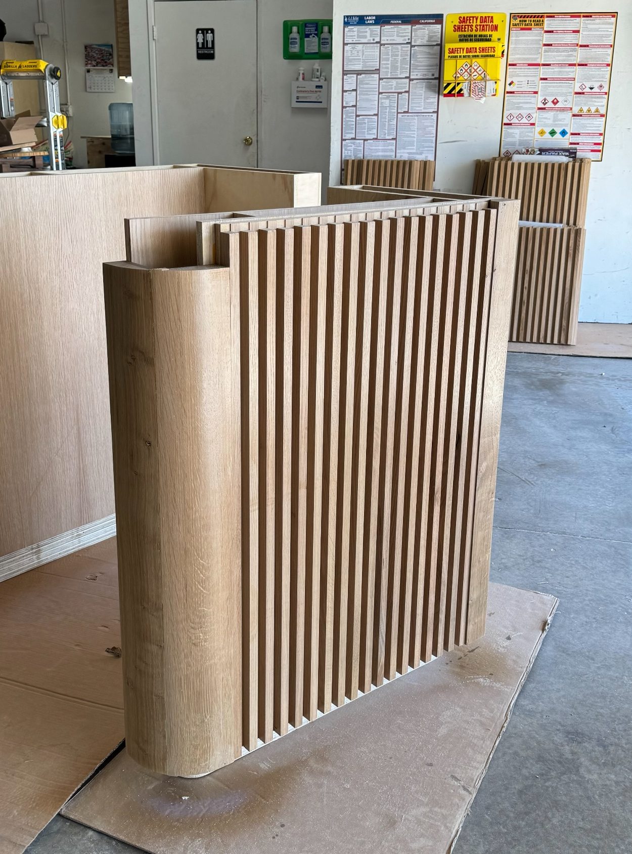Curved slatted wood panel with rounded ends, built in the shop