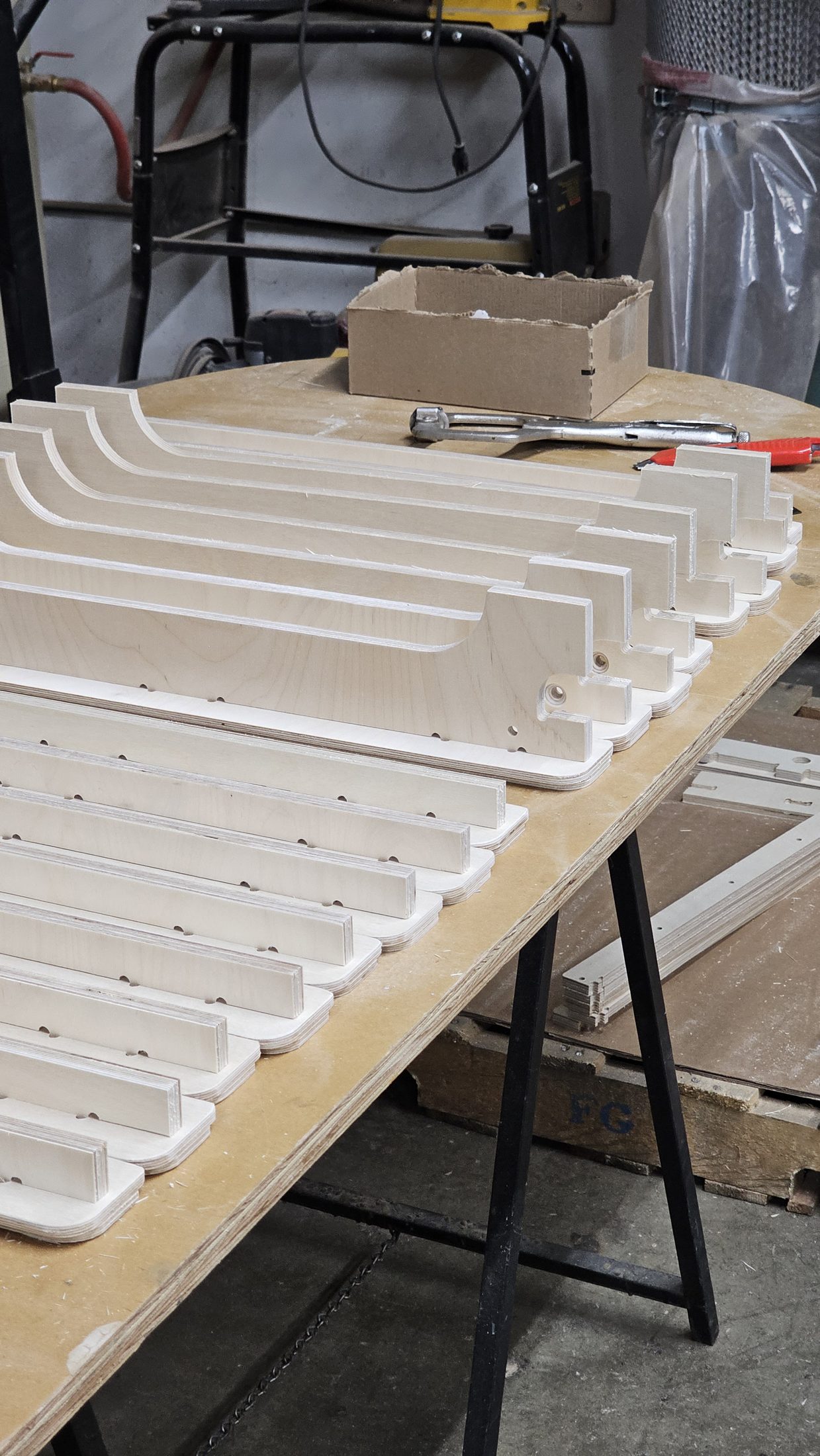 Rows of routed white parts on a bench