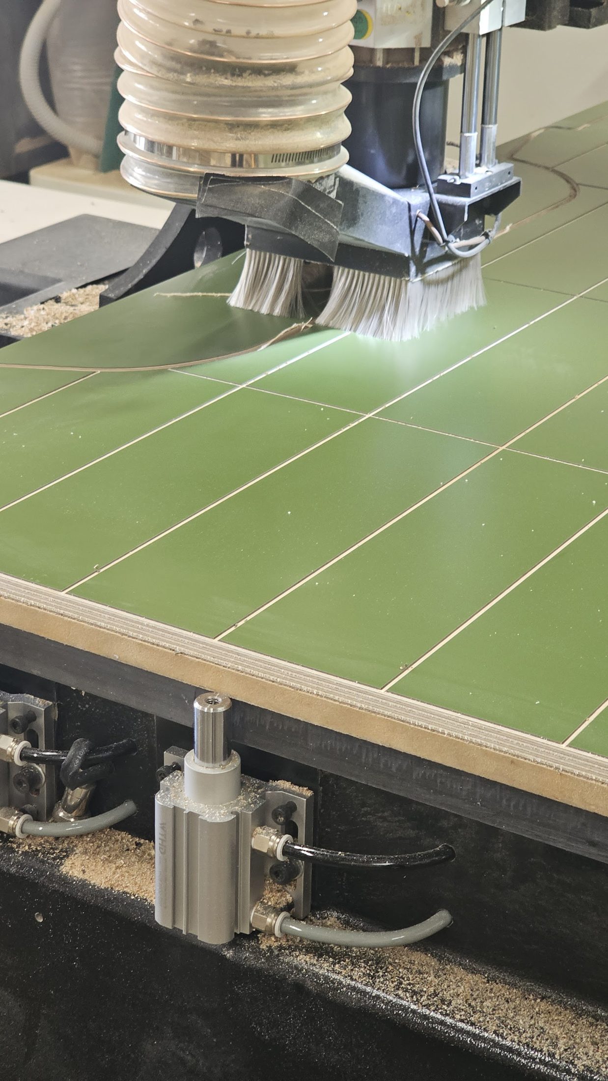 Router cutting grooves into a green laminate panel