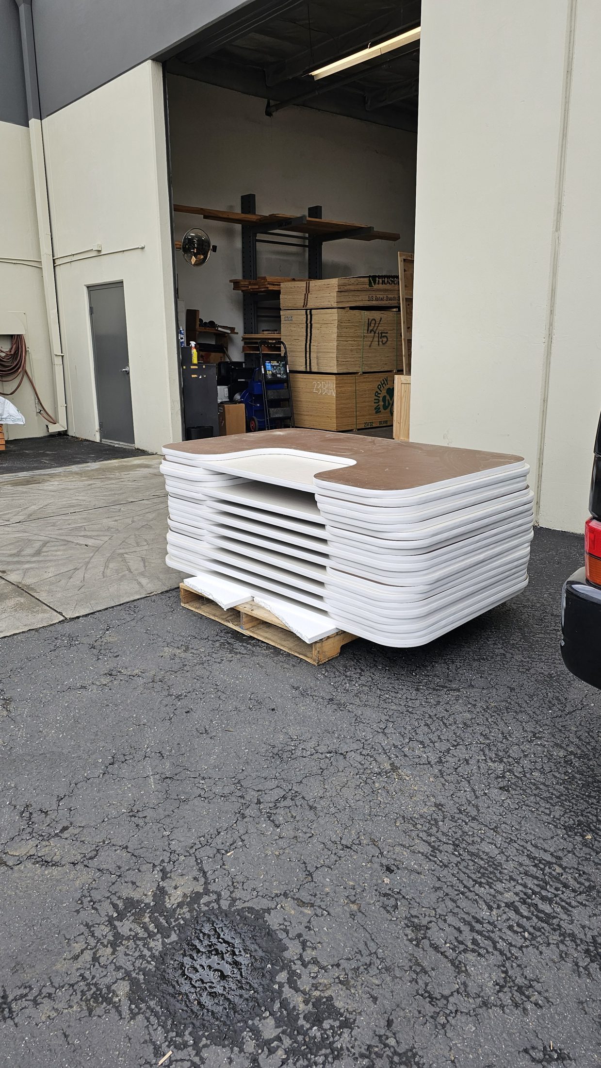Stacked white routed tops on a pallet