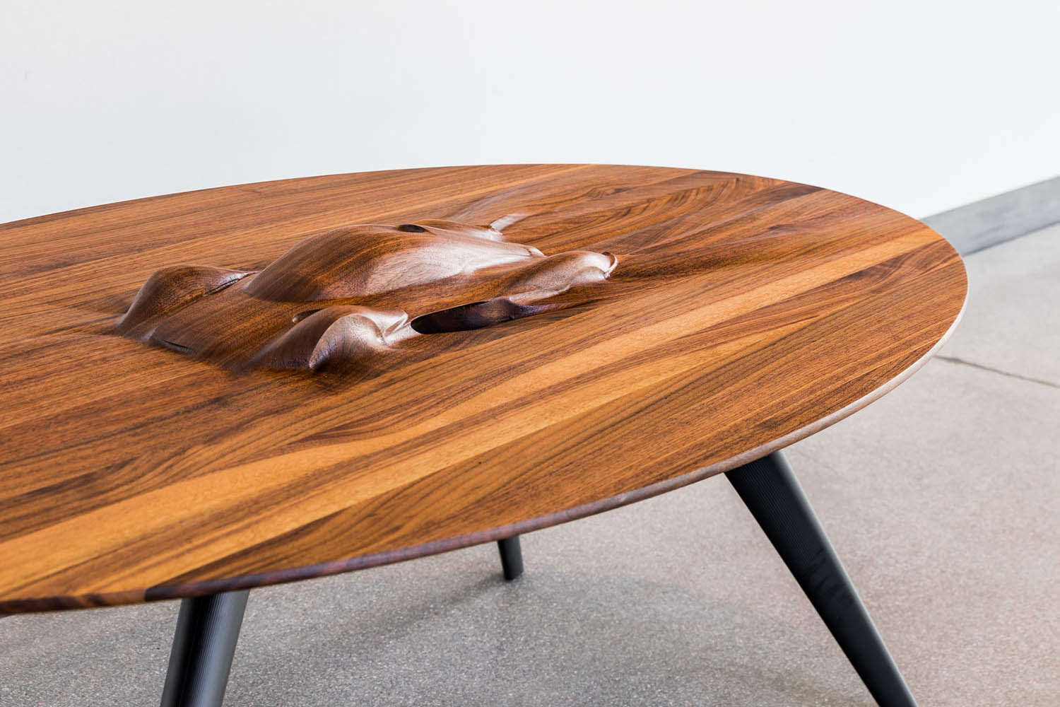 Walnut table with a car form carved into the top