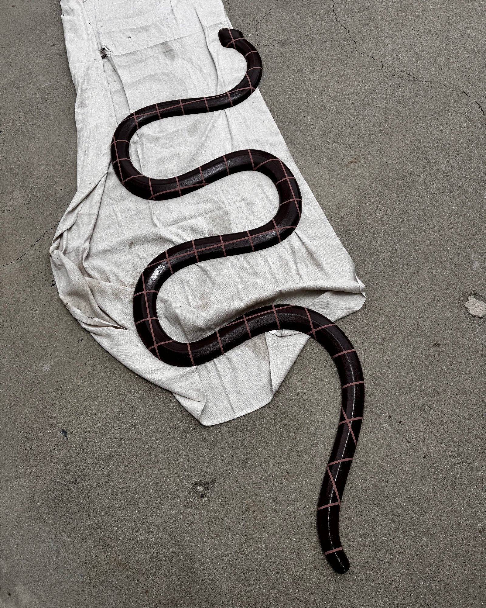 Hand-finished sculptural serpent element with painted grid lines