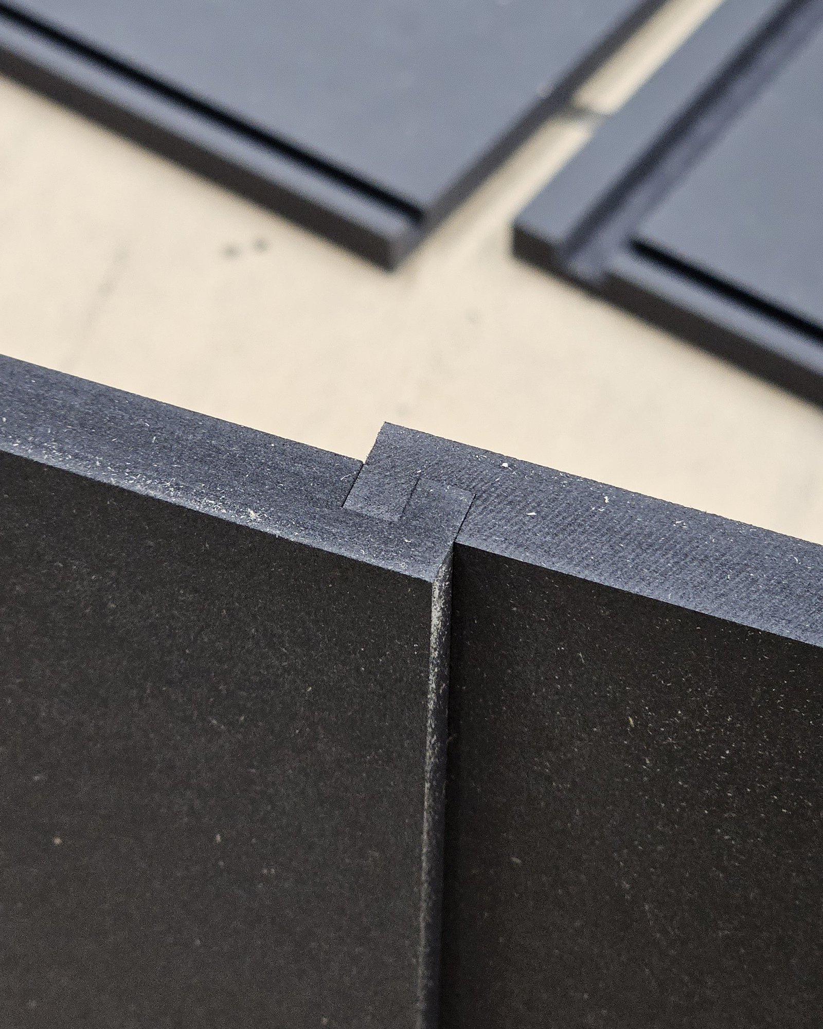 CNC-cut black panel with a precise lap joint