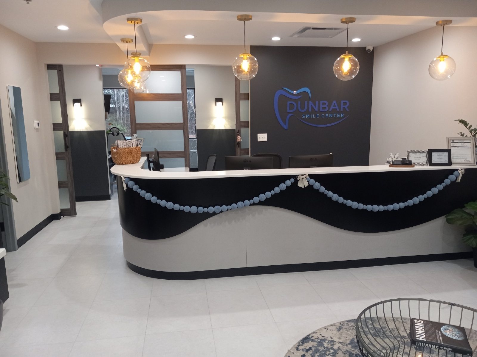 Reception desk and illuminated logo wall at Dunbar Smile Center in Stafford, VA, a Darkhorse Tech dental IT client