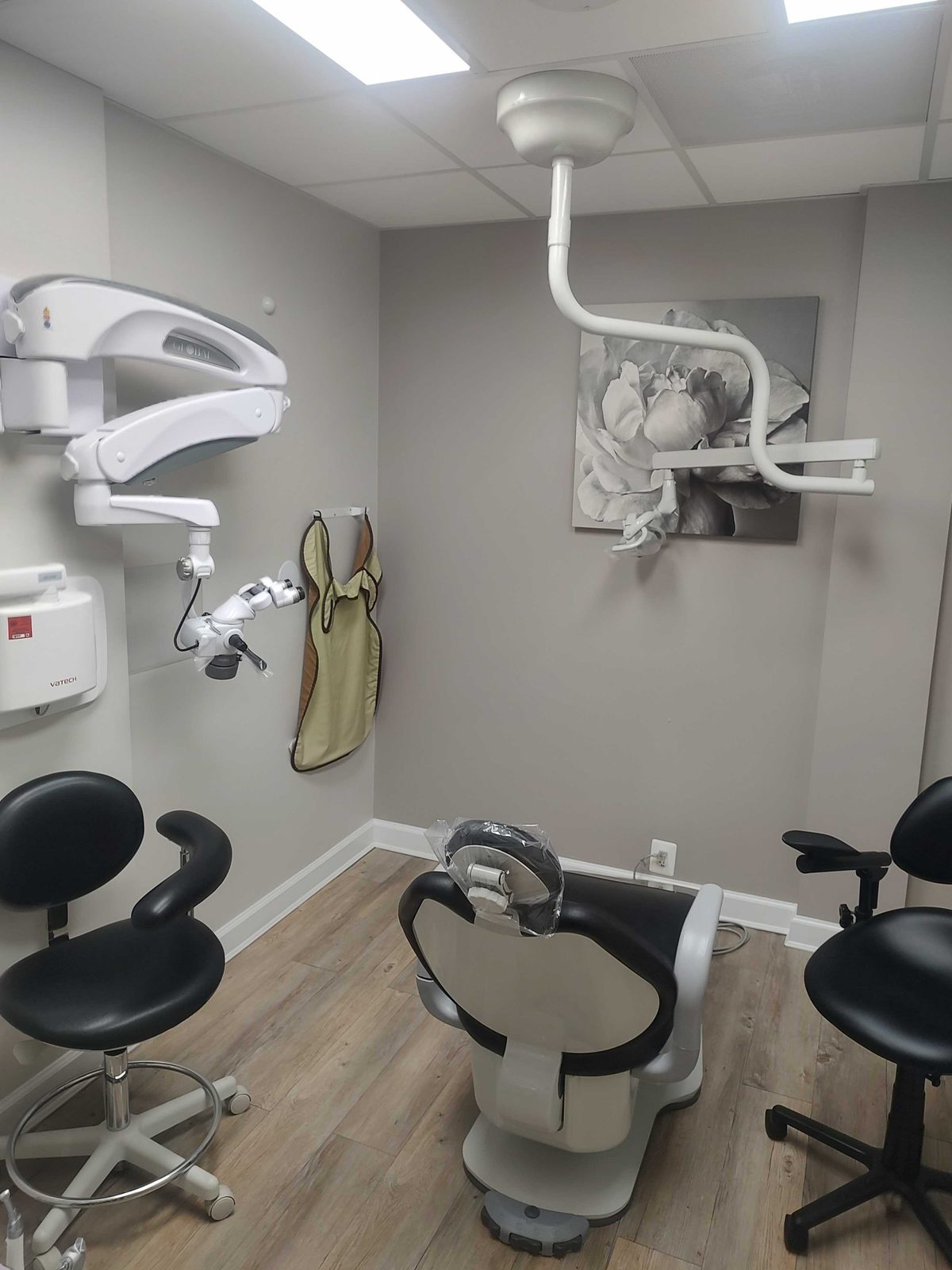 Treatment room with a dental chair, operating microscope and overhead light at Elite Root Canal Specialties in Greenbelt, MD, a Darkhorse Tech dental IT client